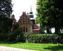 Zdjęcie przedstawia kościół z kamienia i cegły w Sadlnie.                                                                                                                                               