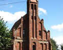 Zdjęcie przedstawia  kościół z czerwonej cegły.                                                                                                                                                         