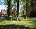 Na zdjęciu znajduje się kilka pomników nagrobnych z Cmentarza Przykościelnego w Barnisławiu. Obok wejście do kościoła.                                                                                  