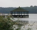 Zdjęcie przedstawia drewniany domek na jeziorze                                                                                                                                                         