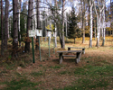 Zdjęcie pokazuje miejsce odpoczynku oraz oznakowanie szlaków turystycznych w lesie                                                                                                                      