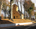 Zdjęcie przedstawia kościół na wzgórzu w otoczeniu starych drzew                                                                                                                                        