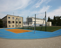 Zdjęcie przedstawia boisko przy budynku szkoły.                                                                                                                                                         