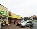 Zdjęcie przedstawia dyskont Biedronka wraz z parkingiem dla klientów.                                                                                                                                   