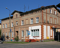 Zdjęcie przedstawia budynek z filią Poczty Polskiej w Rąbinie w widoku od strony przejazdu kolejowego.                                                                                                  