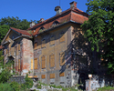 Zdjęcie przedstawia front i ścianę boczną pałacu w Ząbrowie, widok od strony drogi dojazdowej.                                                                                                          
