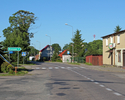 Zdjęcie przedstawia widok na główne skrzyżowanie dróg w Redle w kierunku do Połczyna-Zdroju. Po lewej widoczna przydrożna kapliczka, z prawej sklep spożywczy.                                          