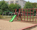 Zdjęcie przedstawia plac zabaw przy osiedlu Nowa w Połczynie Zdroju, na pierwszym planie duża piaskownica ze zjeżdżalnią.                                                                               