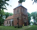 Zdjęcie przedstawia ścianę boczną i front kościoła w Czeninie wraz z najbliższym otoczeniem.                                                                                                            