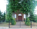 Zdjęcie przedstawia widok na kościół w Karcinie wraz z bramą wjazdową.                                                                                                                                  