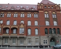 Zdjęcie przedstawia front budynku z czerwonej cegły, w którym miejści się Komenda Wojewódzka Policji                                                                                                    