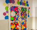 Zdjęcie przedstawia kolorowe drzwi wejściowe do Placu Zabaw Smokuś w Koszalinie.                                                                                                                        