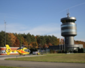 Na zdjęciu widać wieżę kontroli lotów oraz śmigłowiec Lotniczego Pogotowia Ratunkowego.                                                                                                                 