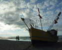 Zdjęcie przedstawia kuter rybacki na plaży w Niechorzu.                                                                                                                                                 